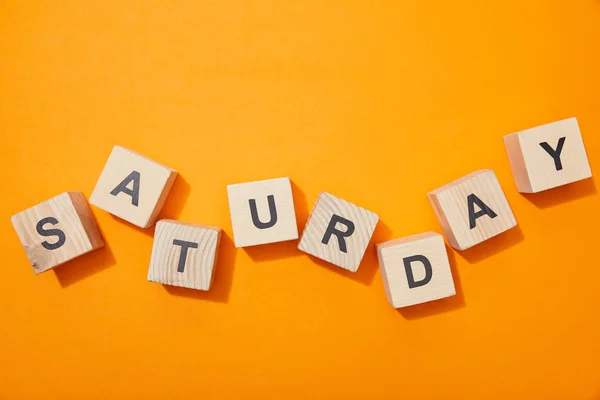 Vista superior de bloques de madera con letras en la superficie naranja - foto de stock