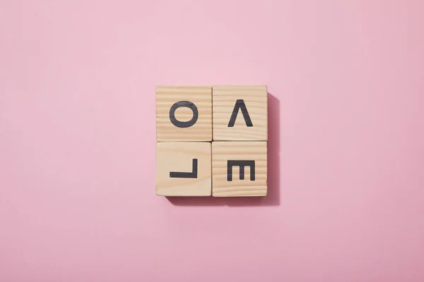 Вид сверху на деревянные кубики с буквами на розовой поверхности — стоковое фото