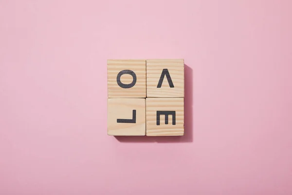 Top view of wooden cubes with letters on pink surface — Stock Photo