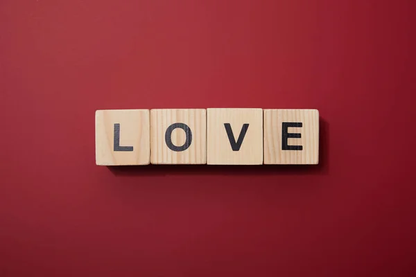 Top view of wooden cubes with letters on red surface — Stock Photo