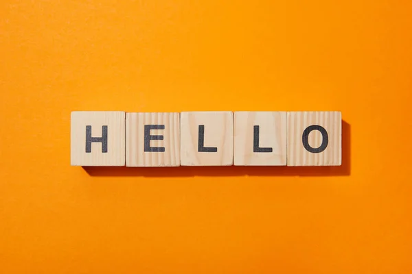 Top view of wooden cubes with letters on orange surface — Stock Photo