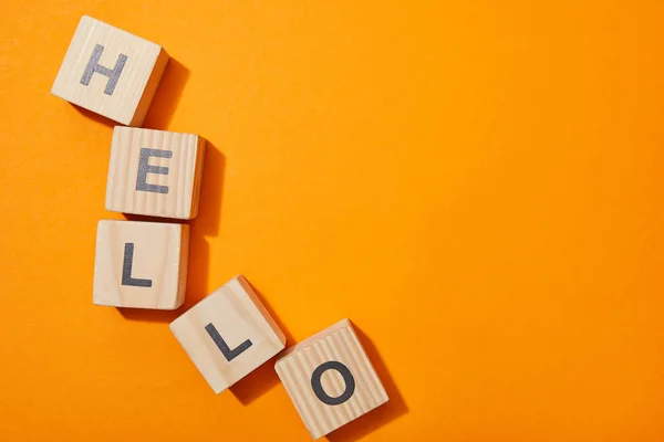 Top view of wooden cubes with letters on orange surface — Stock Photo