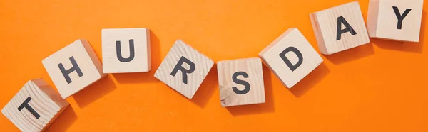 Panoramic shot of wooden cubes with letters on orange surface — Stock Photo