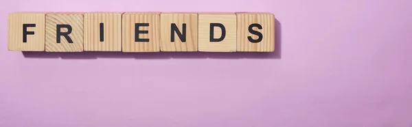 Panoramic shot of wooden cubes with letters on purple surface — Stock Photo