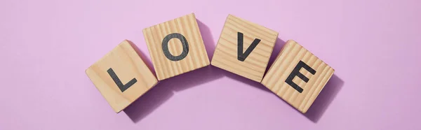 Panoramic shot of wooden cubes with letters on purple surface — Stock Photo