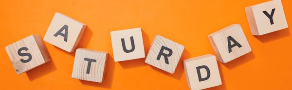 Panoramic shot of wooden cubes with letters on orange surface — Stock Photo