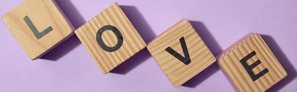 Tiro panorâmico de blocos de madeira com letras na superfície roxa — Fotografia de Stock
