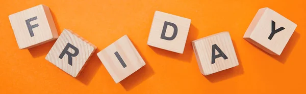 Panoramic shot of wooden cubes with letters on orange surface — Stock Photo