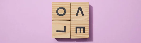 Панорамний знімок дерев'яних блоків з літерами на фіолетовій поверхні — стокове фото