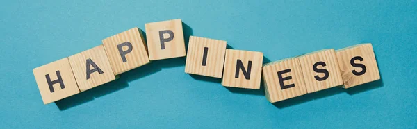 Panoramic shot of wooden cubes with letters on blue surface — Stock Photo