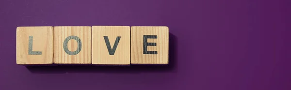 Panoramic shot of wooden cubes with letters on purple surface — Stock Photo