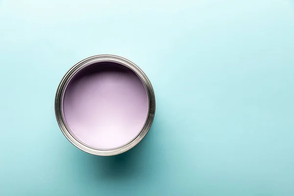 Top view of tin with purple paint on blue surface — Stock Photo