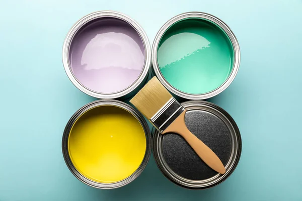 Top view of tins of paints and brush on blue surface — Stock Photo