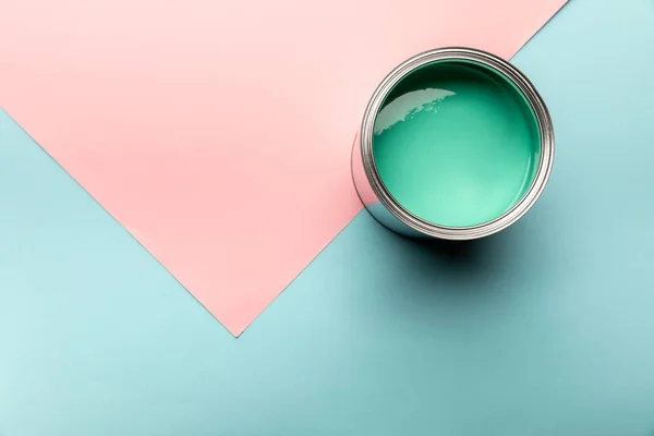 Vista superior de la lata con pintura verde sobre la superficie azul y rosa - foto de stock
