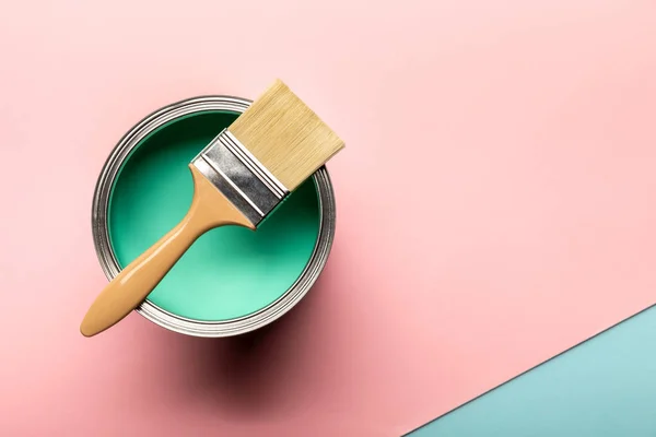 Top view of tin of green paint and brush on pink surface — Stock Photo