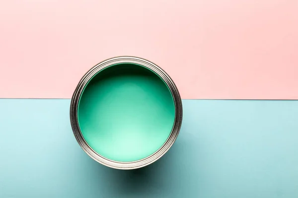 Top view of tin with green paint on pink and blue surface — Stock Photo