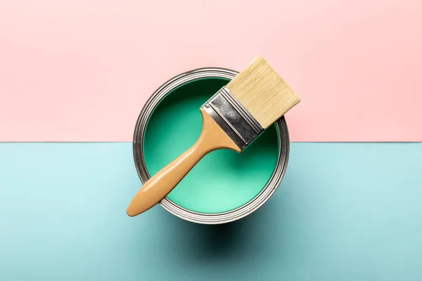 Vista dall'alto di lattina su vernice verde e pennello su superficie rosa e blu — Foto stock