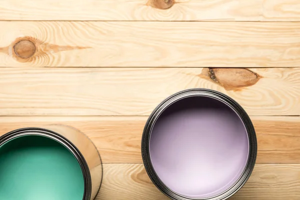 Vista superior de latas com tintas na superfície de madeira — Fotografia de Stock