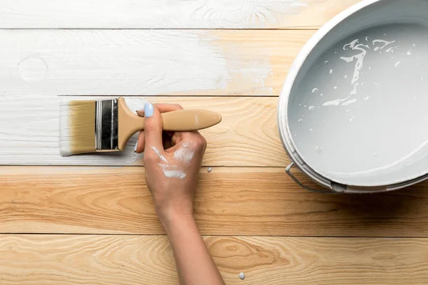 Vista recortada de la mujer pintando la superficie de madera en blanco — Stock Photo