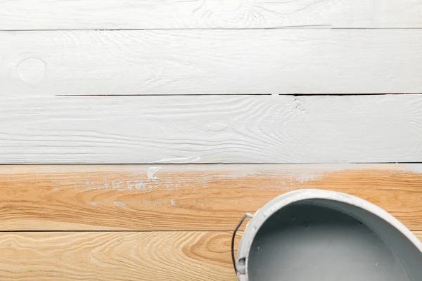 Top view of bucket with white paint on wooden surface — Stock Photo