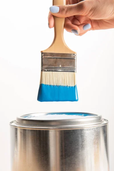 Partial view of woman holding brush with blue paint isolated on white — Stock Photo