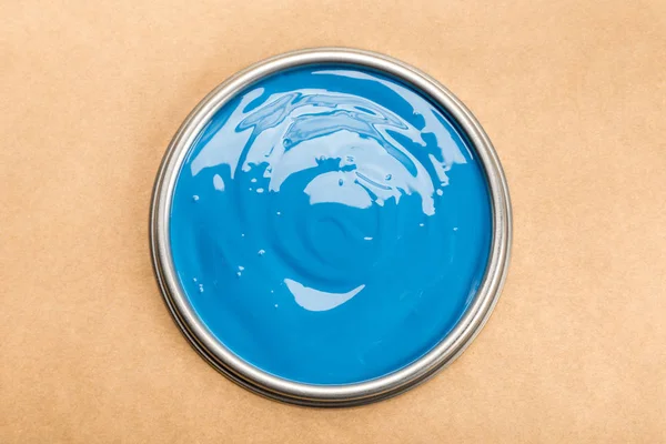 Top view of tin with blue paint isolated on brown — Stock Photo