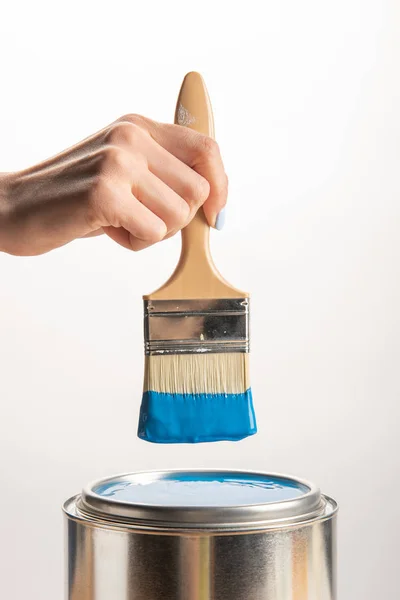 Partial view of woman holding brush with blue paint isolated on white — Stock Photo