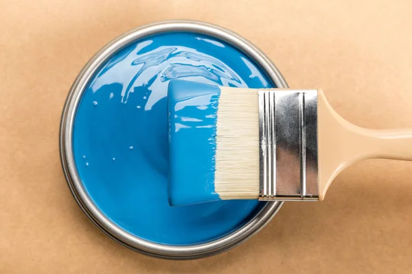 Вид зверху з олова з синьою фарбою і пензлем на коричневому — стокове фото