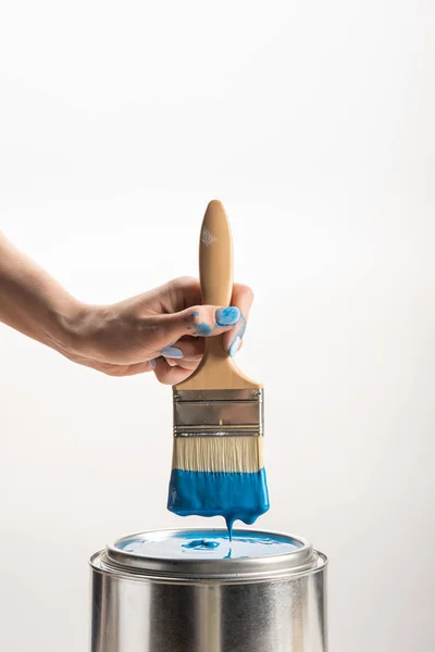 Partial view of woman holding brush with blue paint on white — Stock Photo