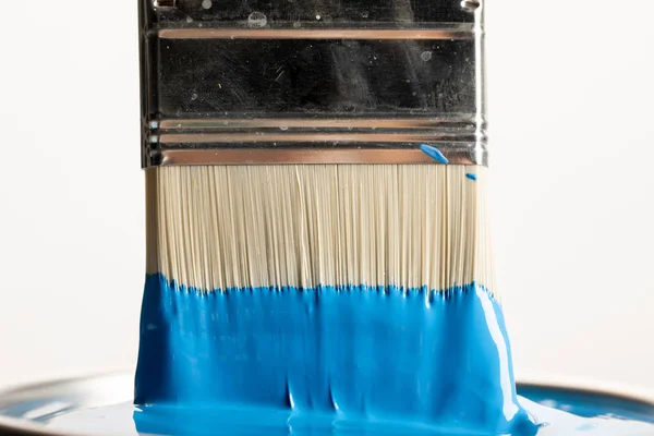 Vista de cerca del pincel con pintura azul sobre lata aislada en blanco - foto de stock