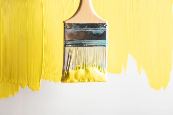 Vue de dessus du pinceau sur la surface jaune peinte — Photo de stock