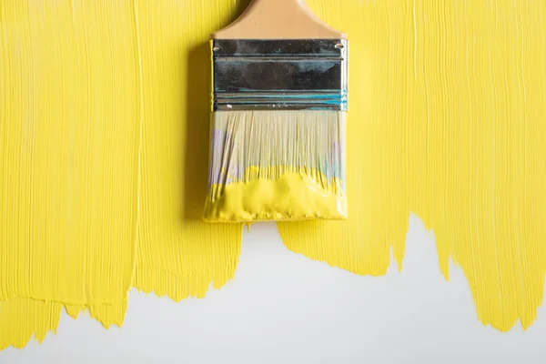 Top view of brush on painted yellow surface — Stock Photo