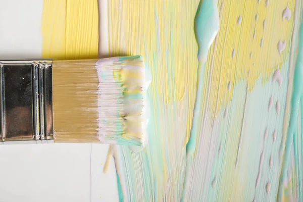 Vista superior da escova e pinceladas coloridas na superfície branca — Fotografia de Stock