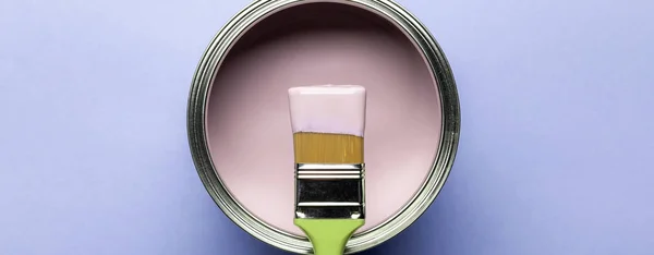 Panoramic shot of can with pink paint and brush on purple surface — Stock Photo