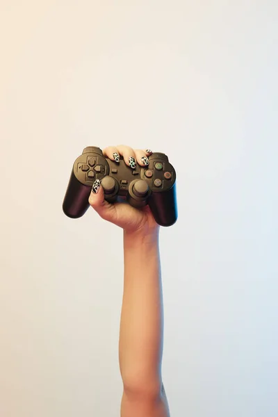 KYIV, UKRAINE - APRIL 5, 2019: Cropped view of young woman holding black joystick on beige — Stock Photo