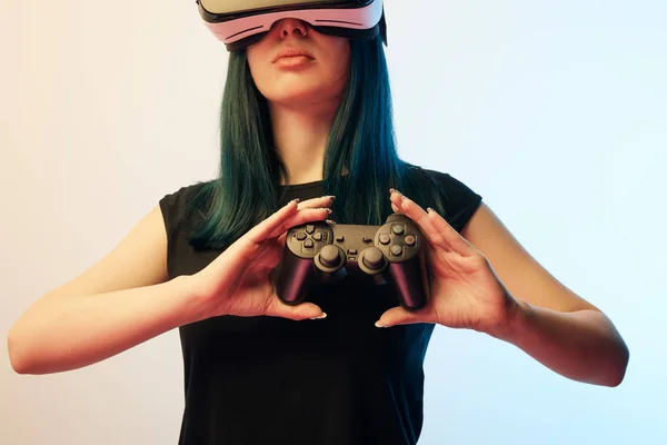 KYIV, UKRAINE - APRIL 5, 2019: Cropped view of brunette woman holding joystick while wearing virtual reality headset on beige and blue — Stock Photo
