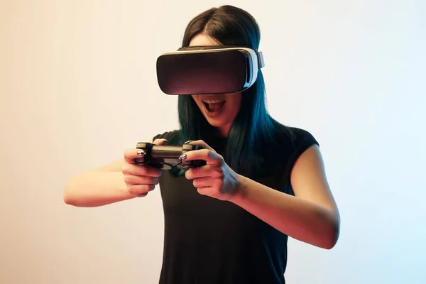 KYIV, UCRANIA - 5 DE ABRIL DE 2019: Mujer morena alegre jugando a videojuegos con auriculares de realidad virtual en beige y azul - foto de stock