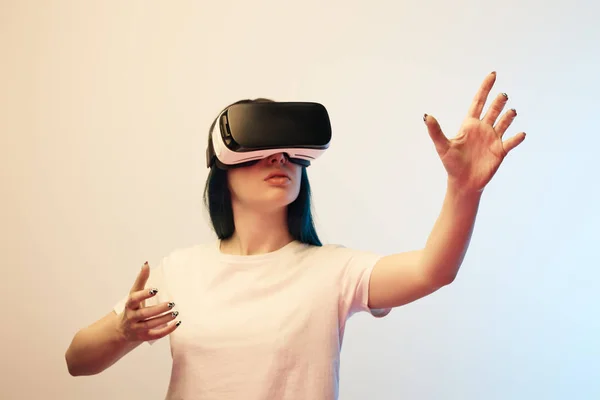 Brunette girl in virtual reality headset gesturing on beige and blue — Stock Photo