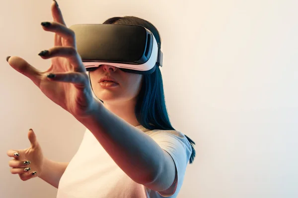 Selective focus of woman in virtual reality headset gesturing on beige — Stock Photo