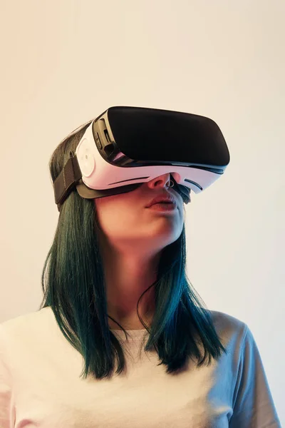 Jovem mulher em t-shirt branca vestindo fone de ouvido realidade virtual no bege — Fotografia de Stock