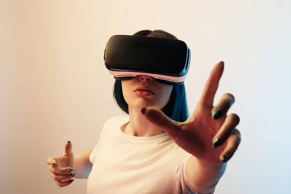 Selective focus of brunette woman wearing virtual reality headset and gesturing on beige and blue — Stock Photo