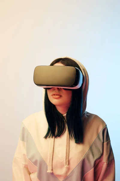 Beautiful brunette woman in virtual reality headset on beige and blue — Stock Photo