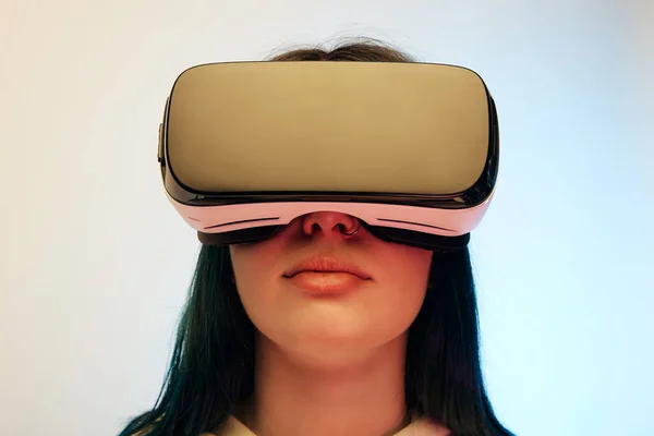 Low angle view of brunette woman in virtual reality headset on beige and blue — Stock Photo