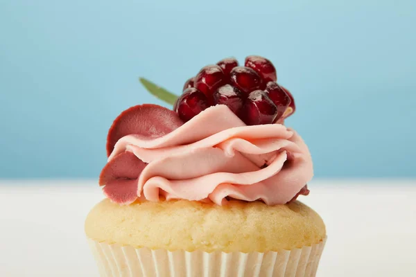 Cupcake saboroso com creme na superfície branca isolada em azul — Fotografia de Stock