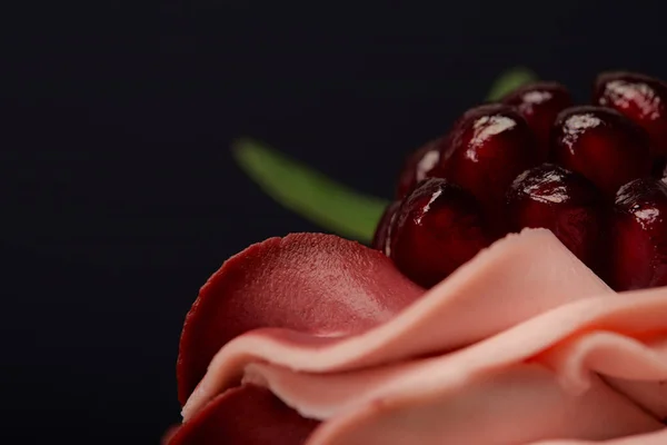 Vista de cerca de crema dulce y granate aislado en negro - foto de stock