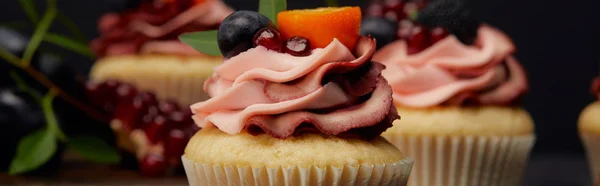 Panoramic shot of cupcakes with cream, fruits and berries — Stock Photo