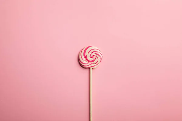 Top view of delicious multicolored swirl lollipop on wooden stick on pink background — Stock Photo