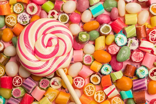 Vue de dessus de délicieux bonbons au caramel multicolore lumineux et sucette — Photo de stock