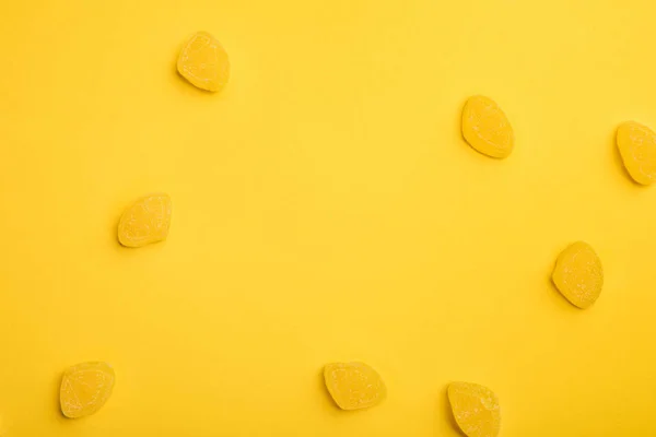 Вид вкусных лимонных желе, разбросанных на желтом фоне — Stock Photo