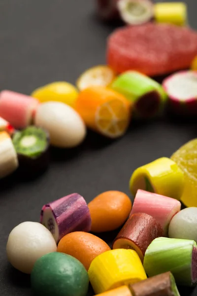 Foyer sélectif de délicieux bonbons au caramel aux fruits multicolores sur fond noir — Photo de stock